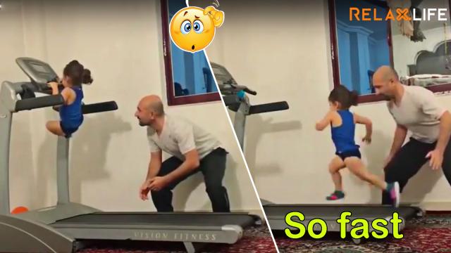 Little girl runs on the walking machine under her daddy's instruction