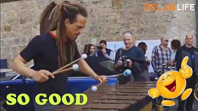 An artist plays a special wood piano in a corner of the street attact many audiences